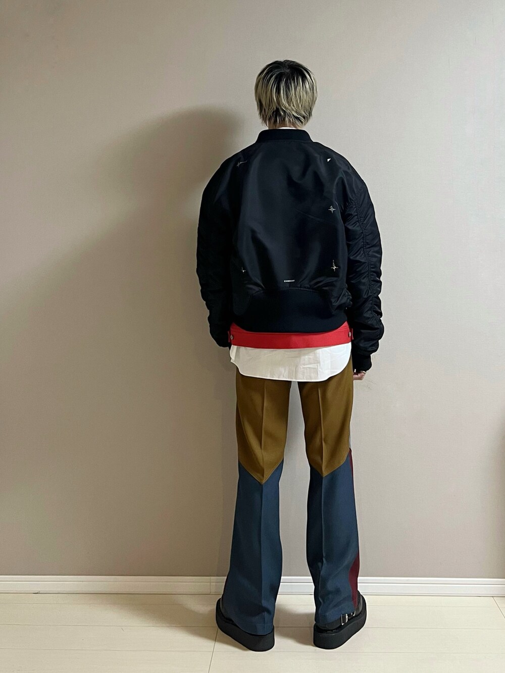 その他のスラックス、ブラック系のシューズ、レッド系のブルゾンを着用したメンズの冬コーディネートの3枚目の写真