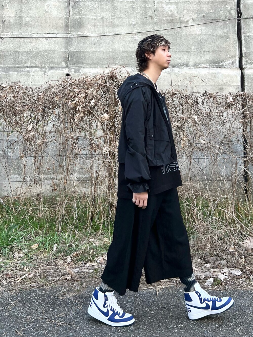 ブラック系のパンツ、ブルー系のスニーカー、ブラック系のTシャツ/カットソーを着用したメンズの春コーディネートの2枚目の写真