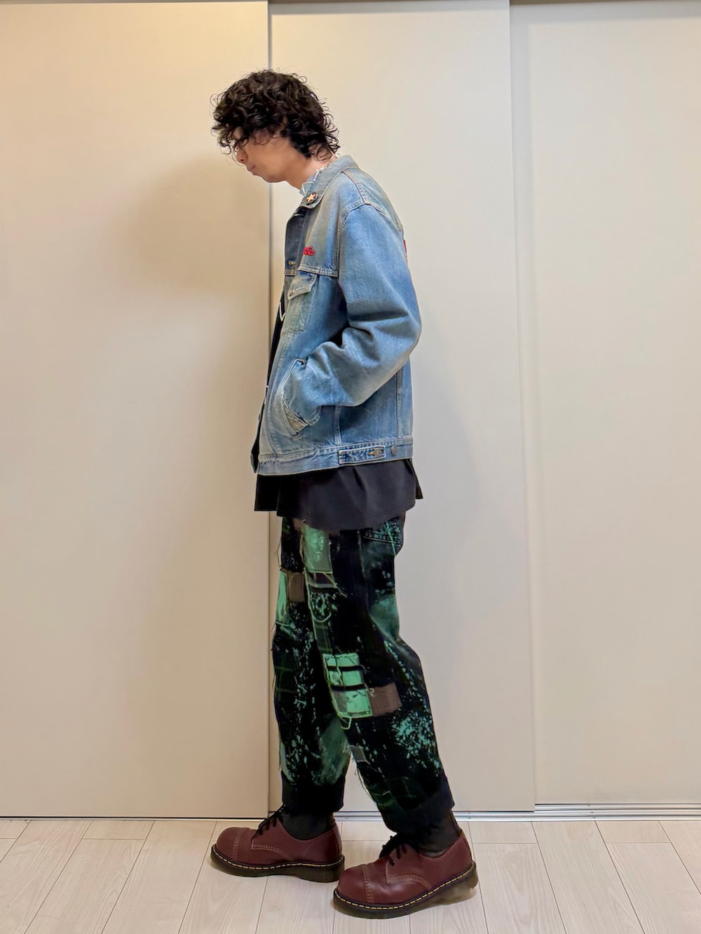 グリーン系のデニムパンツ、その他のブーツ、ブラック系のTシャツ/カットソーを着用したメンズの冬コーディネートの2枚目の写真