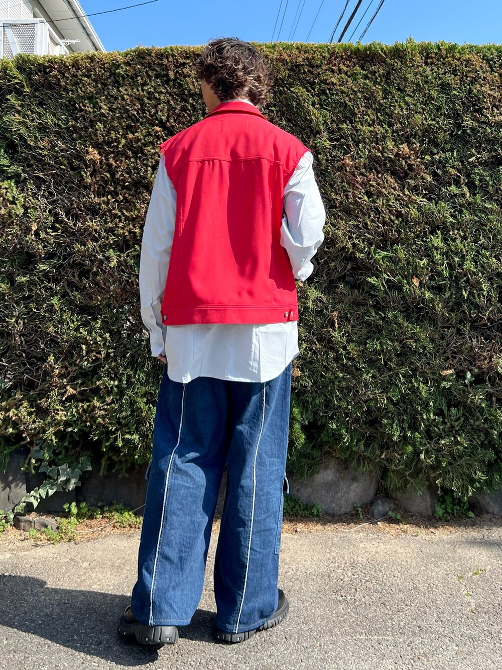 ブラック系のドレスシューズ、ブルー系のデニムパンツ、レッド系のブルゾンを着用したメンズの春コーディネートの3枚目の写真