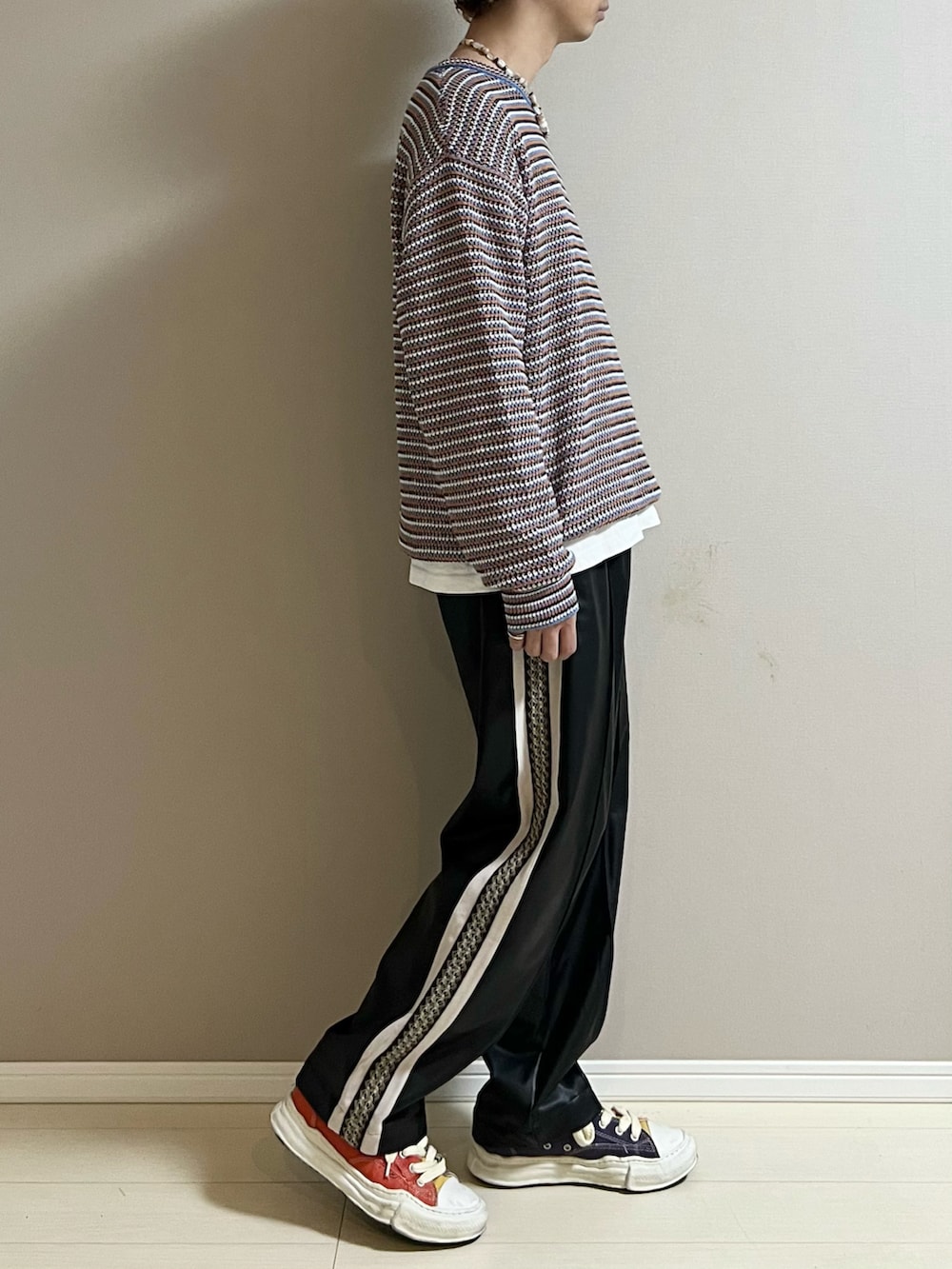 ブラック系のその他パンツ、その他のスニーカー、ピンク系のネックレスを着用したメンズの冬コーディネートの2枚目の写真