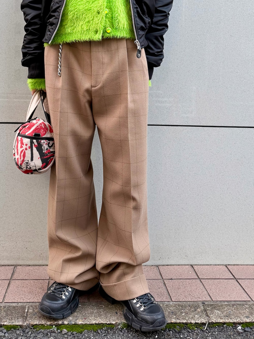 ベージュ系のスラックス、ブラック系のシューズ、ブラック系のMA-1を着用したメンズの秋コーディネートの5枚目の写真