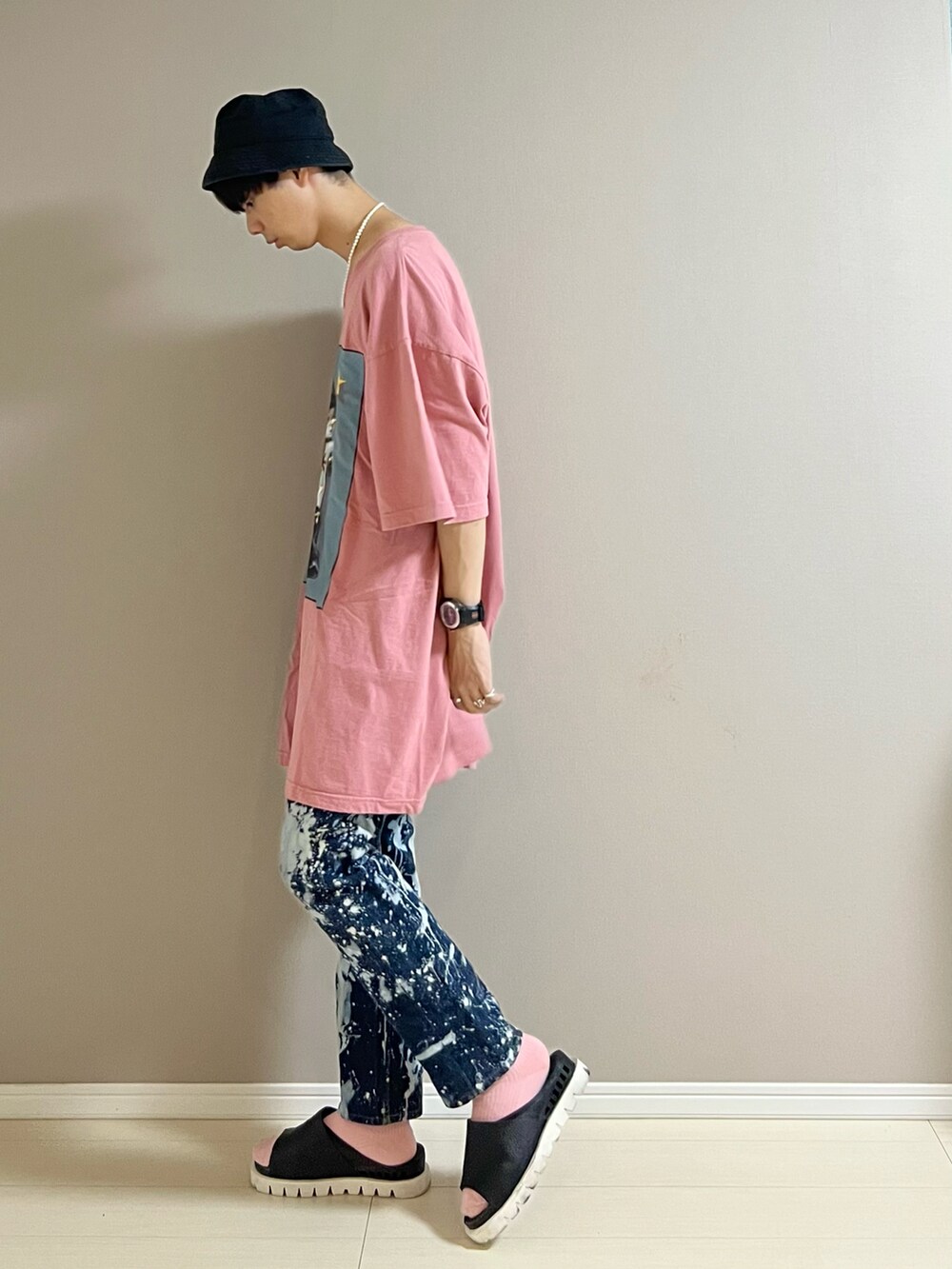 ブラック系のサンダル、ピンク系のTシャツ/カットソー、ブラック系のキャップを着用したメンズの夏コーディネートの3枚目の写真