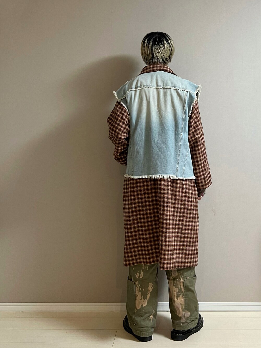 オレンジ系のステンカラーコート、ブルー系のデニムジャケット、ブラック系のショルダーバッグを着用したメンズの冬コーディネートの3枚目の写真