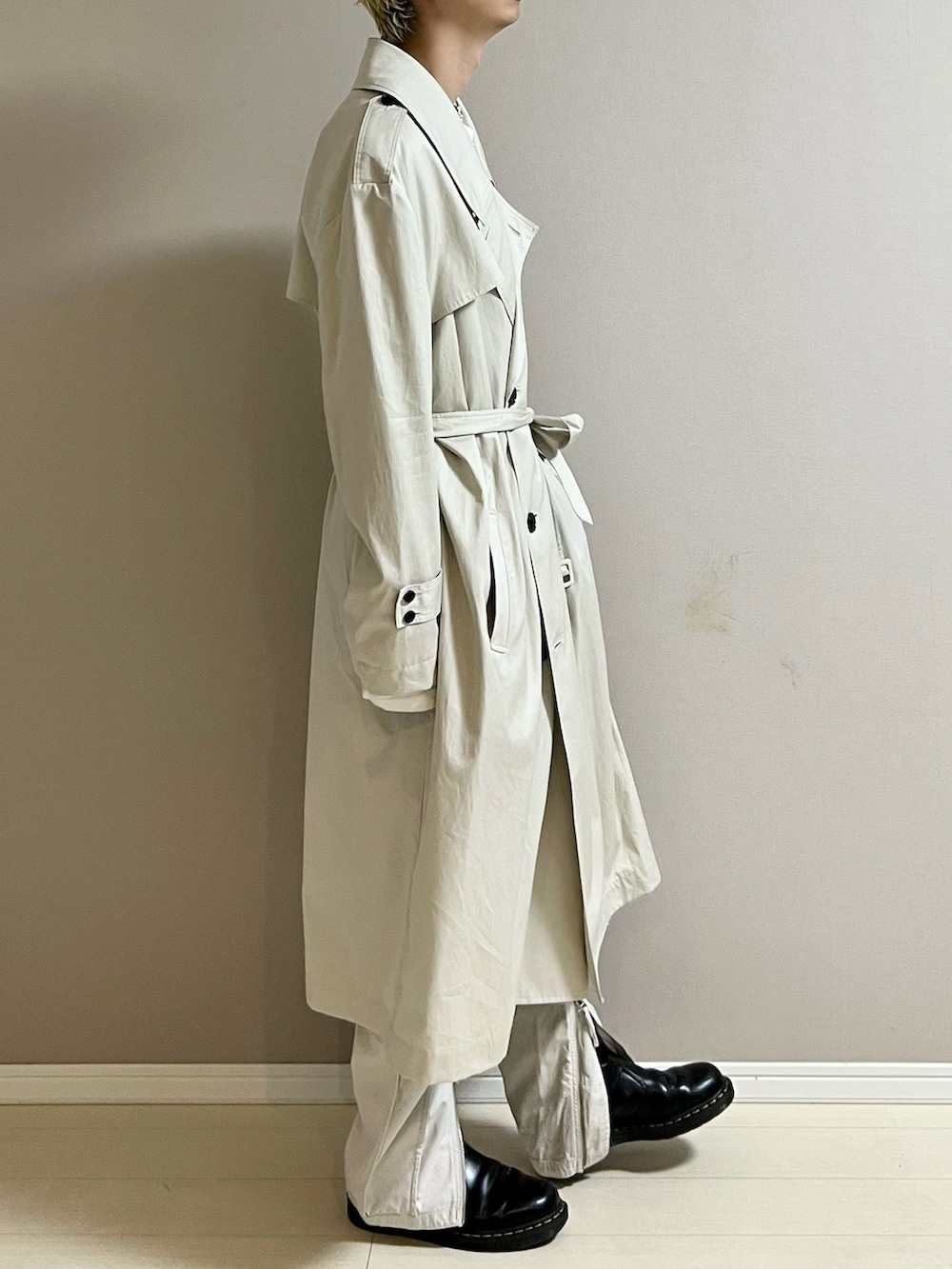 ブラック系のブーツ、ベージュ系のトレンチコート、ベージュ系のその他パンツを着用したメンズの秋コーディネートの2枚目の写真