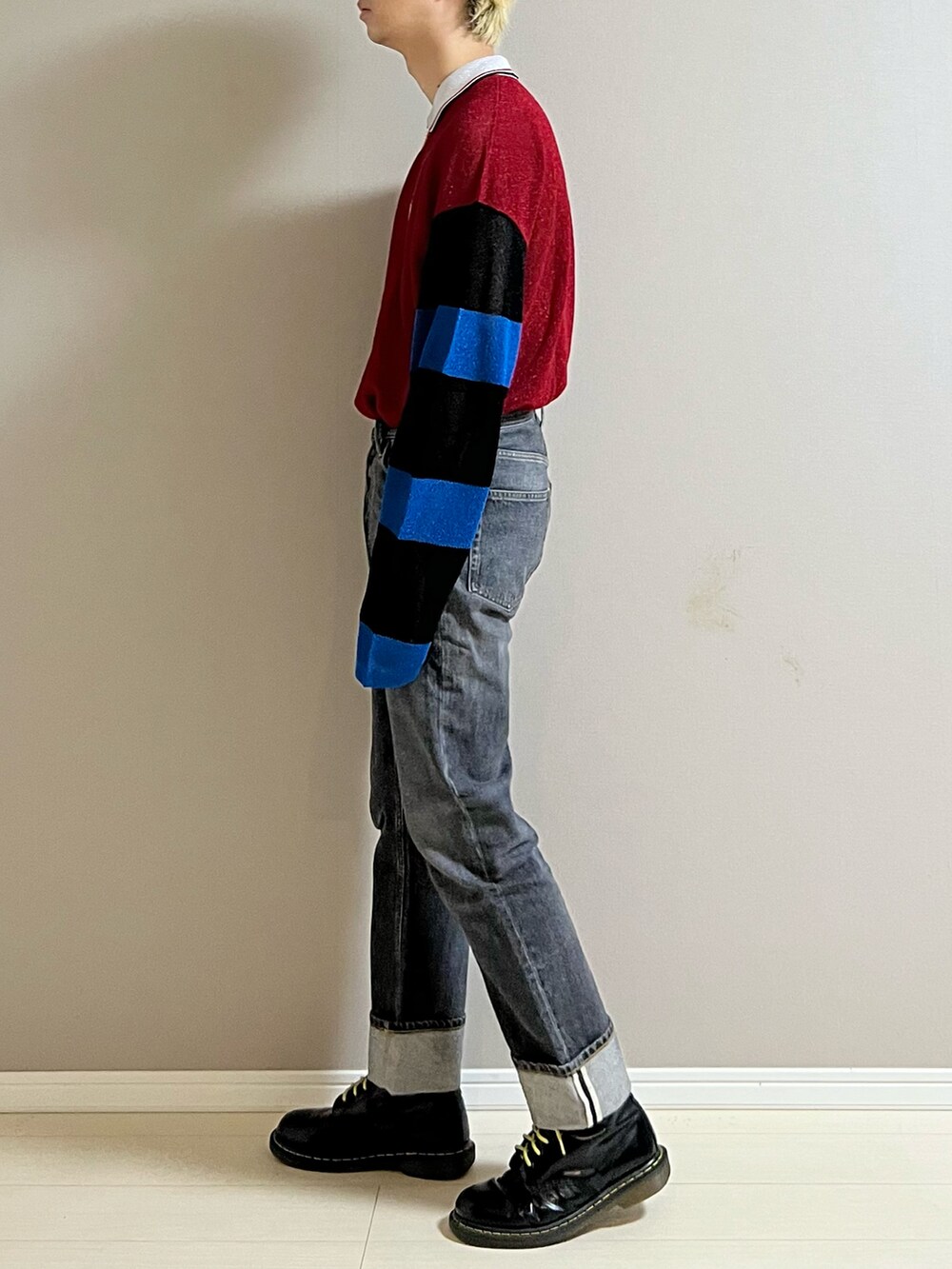 ブラック系のデニムパンツ、ブラック系のブーツ、レッド系のシャツ/ブラウスを着用したメンズの秋コーディネートの2枚目の写真