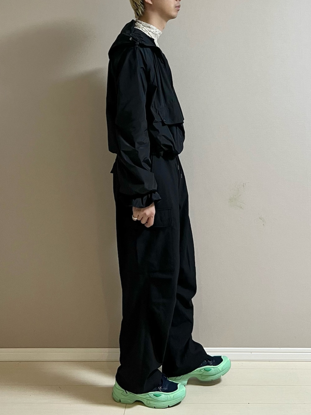 ブルー系のスニーカー、ブラック系のカーゴパンツ、ブラック系のナイロンジャケットを着用したメンズの秋コーディネートの2枚目の写真