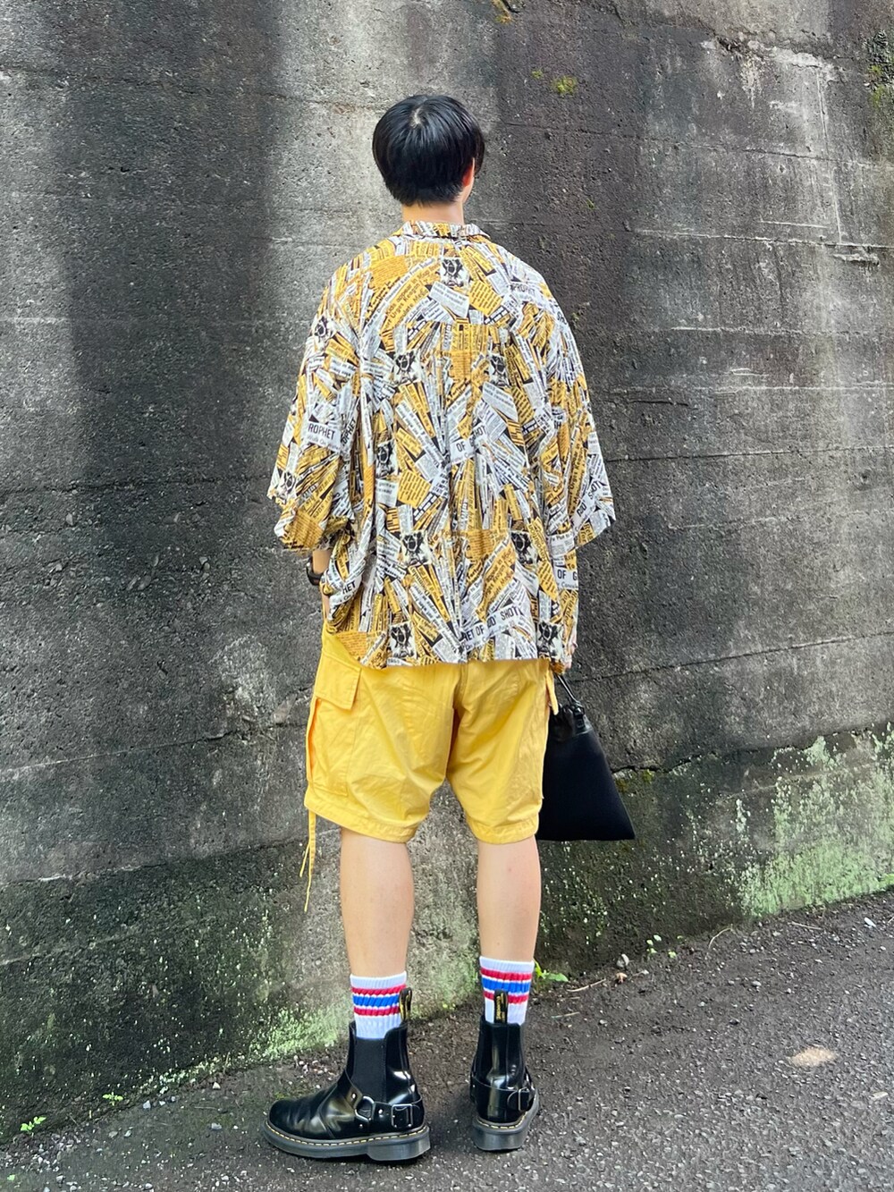 ブラック系のブーツ、ブラック系のショルダーバッグ、イエロー系のカーゴパンツを着用したメンズの夏コーディネートの3枚目の写真