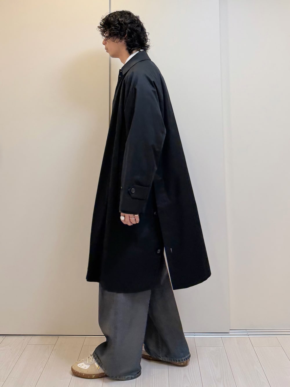 ブラック系のその他アウター、ブラック系のカーディガン/ボレロ、ブラウン系のデニムパンツを着用したメンズの冬コーディネートの2枚目の写真