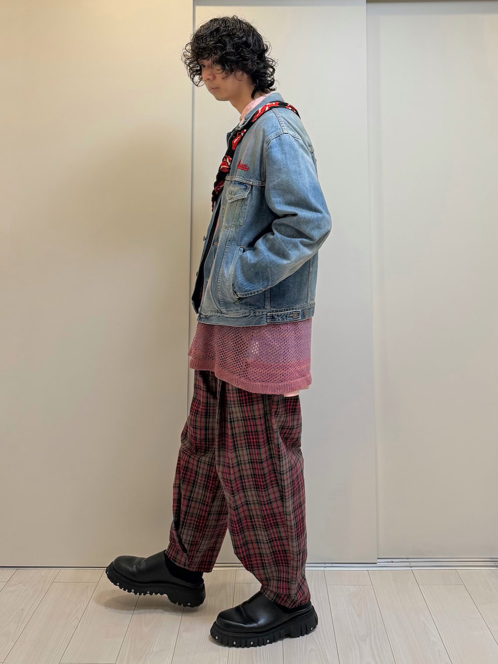 レッド系のパンツ、ブラック系のドレスシューズ、ブルー系のデニムジャケットを着用したメンズの春コーディネートの2枚目の写真