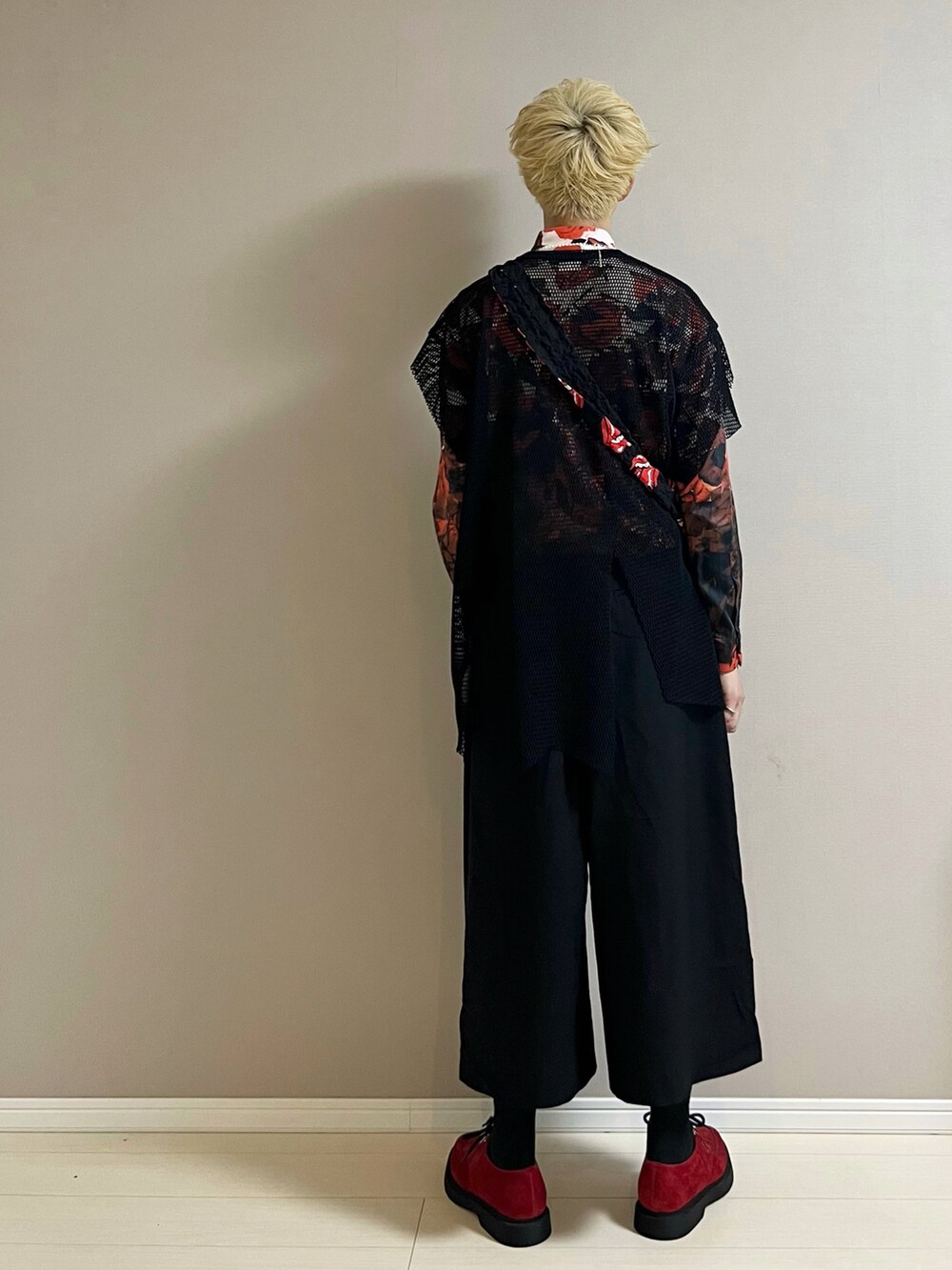 レッド系のシューズ、ブラック系のパンツ、ブラック系のショルダーバッグを着用したメンズの秋コーディネートの3枚目の写真