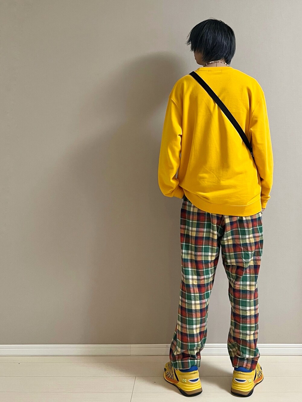 その他のパンツ、イエロー系のスニーカー、ブラック系のショルダーバッグを着用したメンズの春コーディネートの3枚目の写真