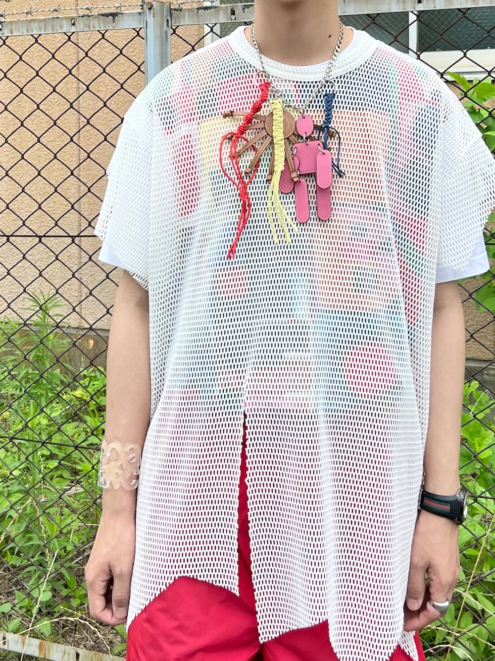 ホワイト系のスニーカー、レッド系のその他パンツ、ホワイト系のTシャツ/カットソーを着用したメンズの夏コーディネートの2枚目の写真