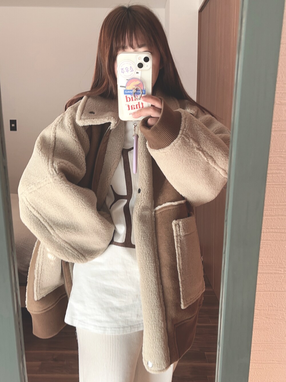 ベージュ系のムートンコート、ホワイト系のその他パンツを着用したレディースの冬コーディネートの2枚目の写真