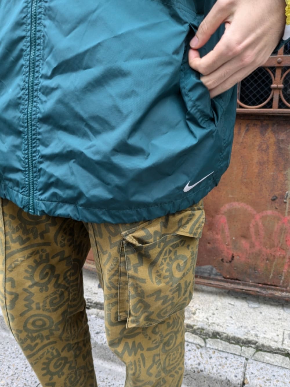 グリーン系のナイロンジャケットを着用したメンズの秋コーディネートの5枚目の写真