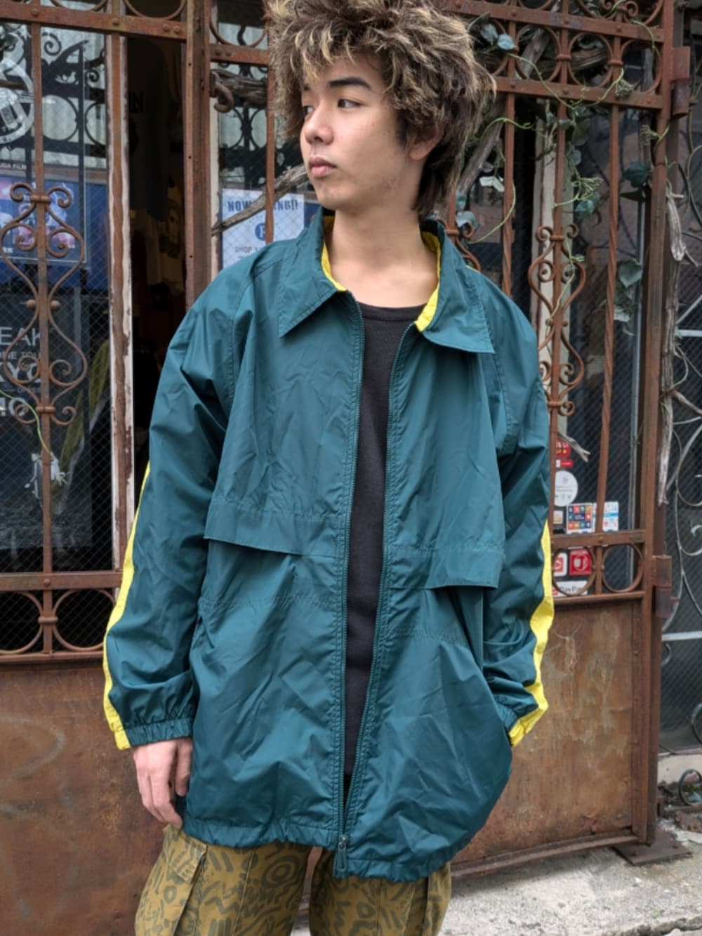 グリーン系のナイロンジャケットを着用したメンズの秋コーディネートの3枚目の写真