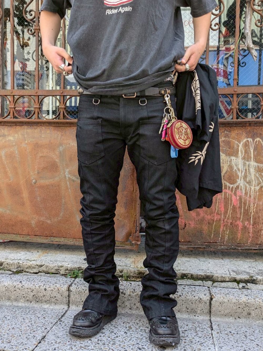 ブラック系のTシャツ/カットソー、ブラック系のデニムパンツ、レッド系のコインケースを着用したメンズの夏コーディネートの3枚目の写真