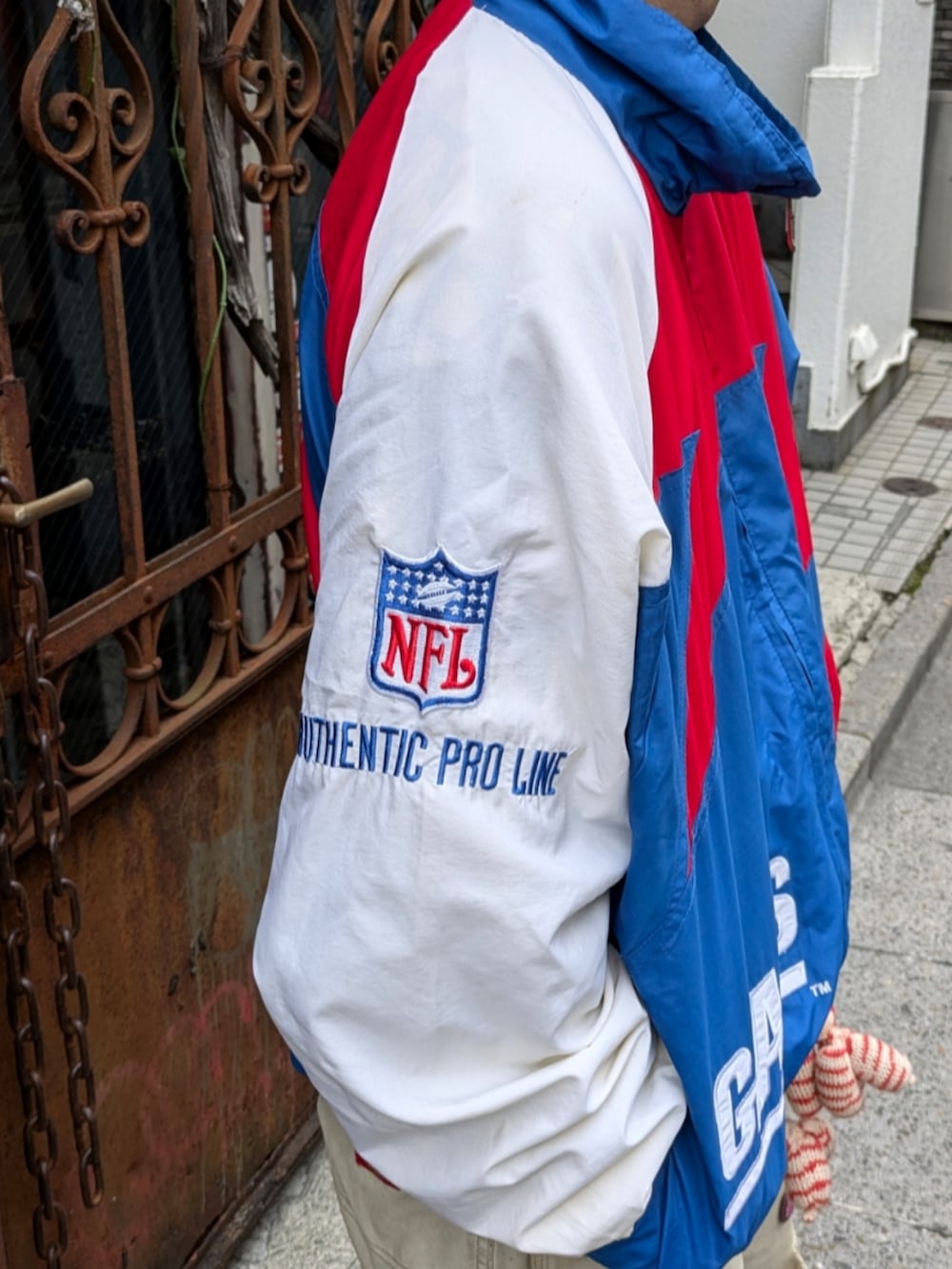 ブルー系のナイロンジャケットを着用したメンズの秋コーディネートの3枚目の写真