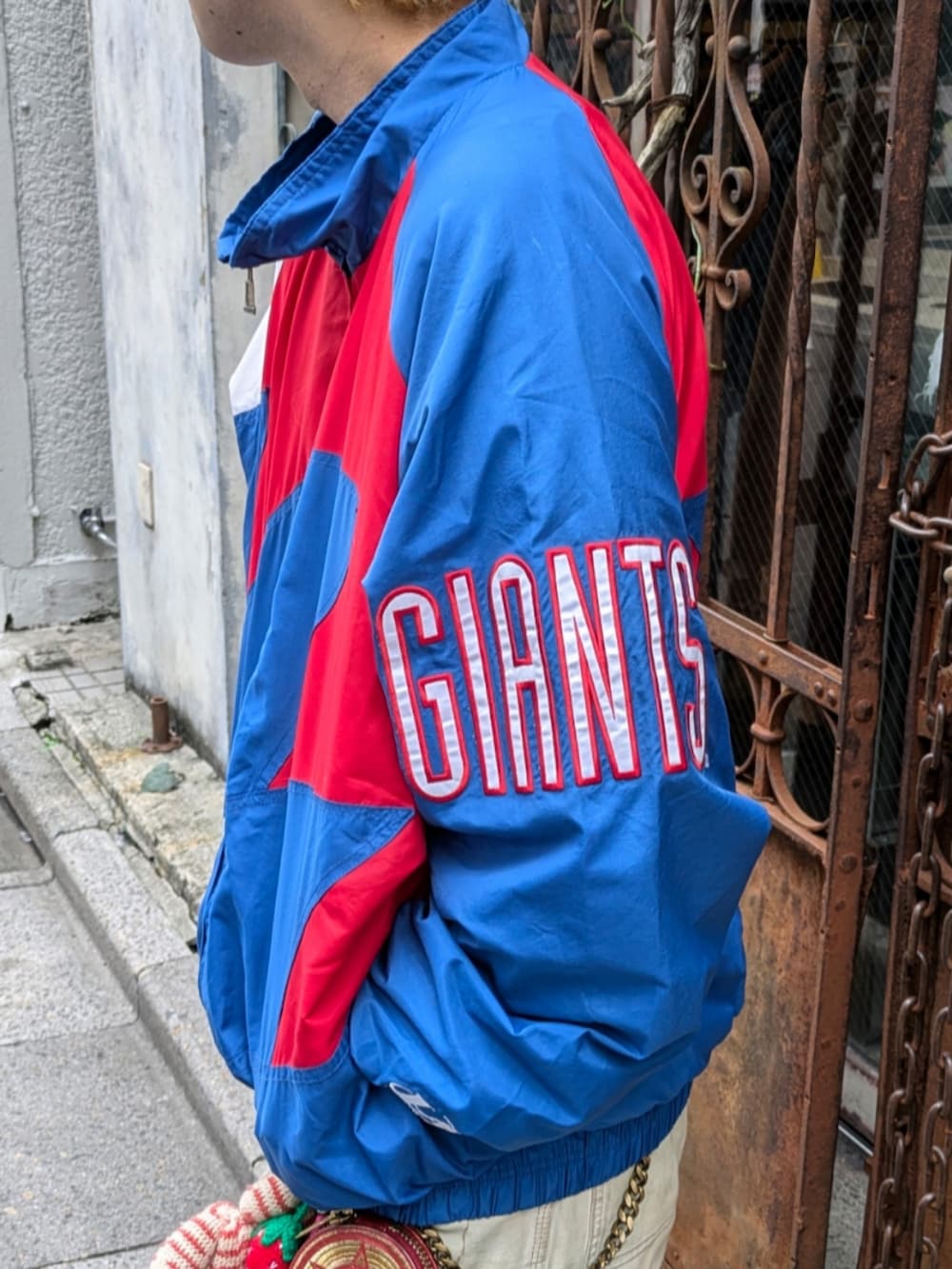 ブルー系のナイロンジャケットを着用したメンズの秋コーディネートの2枚目の写真