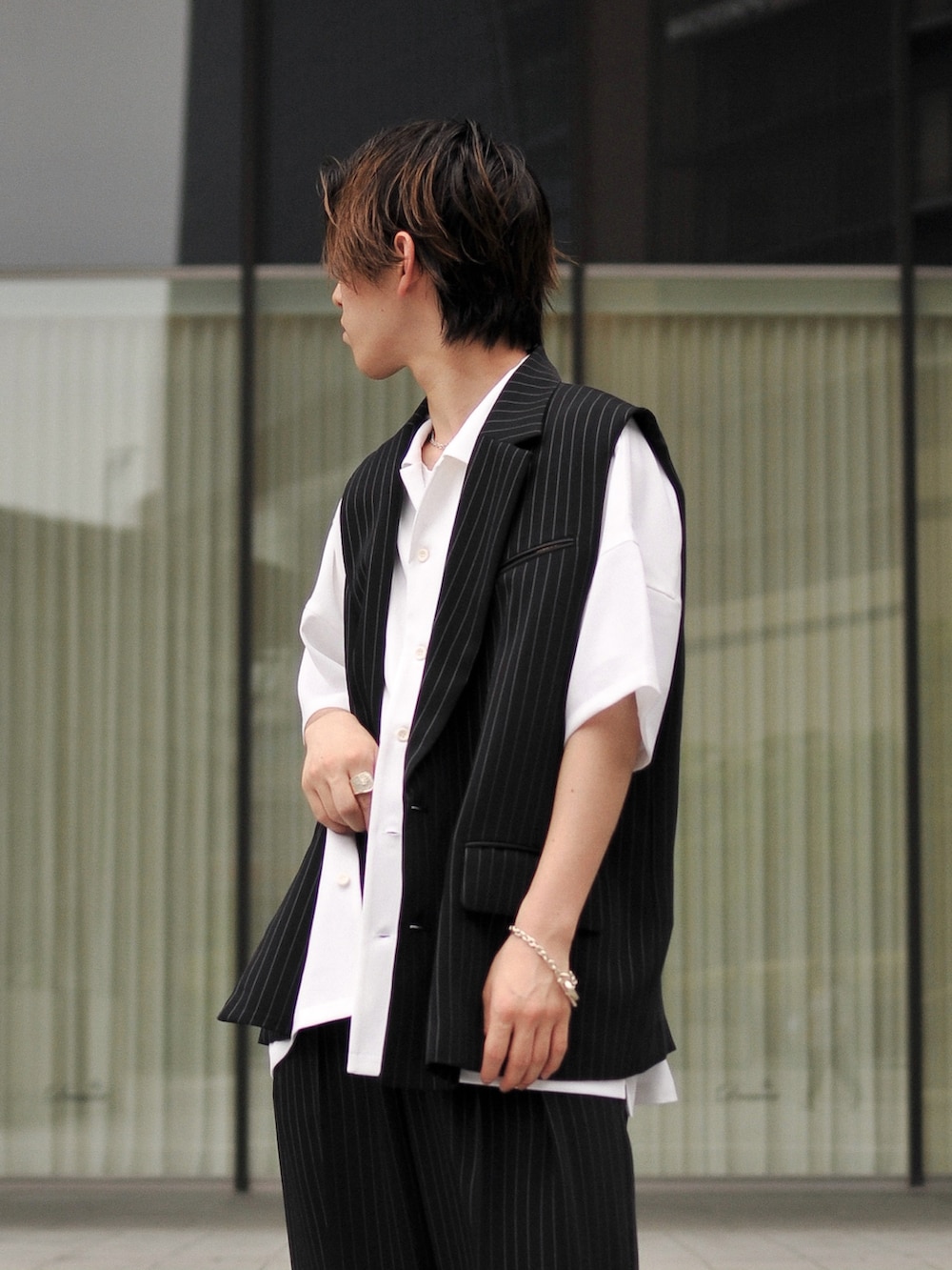 ブラック系のベスト、ホワイト系のシャツ/ブラウス、ブラック系のスラックスを着用したメンズの春コーディネートの3枚目の写真