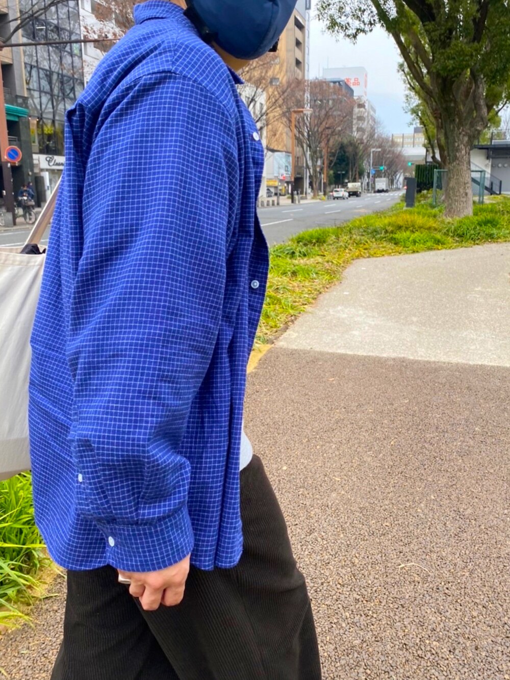 ブラウン系のパンツ、グレー系のスニーカー、ホワイト系のトートバッグを着用したメンズの冬コーディネートの2枚目の写真