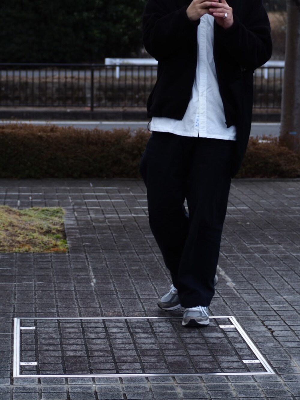 ブルー系のチノパンツ、ブラック系のジャケット/アウター、グレー系のスニーカーを着用したメンズの冬コーディネートの2枚目の写真