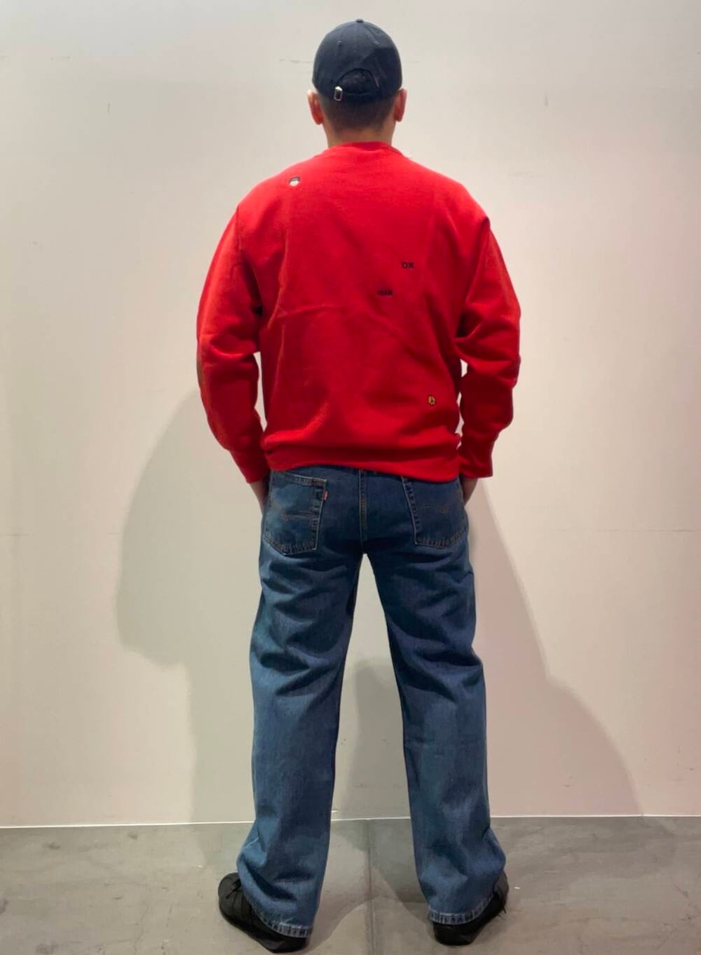 ブルー系のデニムパンツ、レッド系のスウェットを着用したメンズの冬コーディネートの2枚目の写真