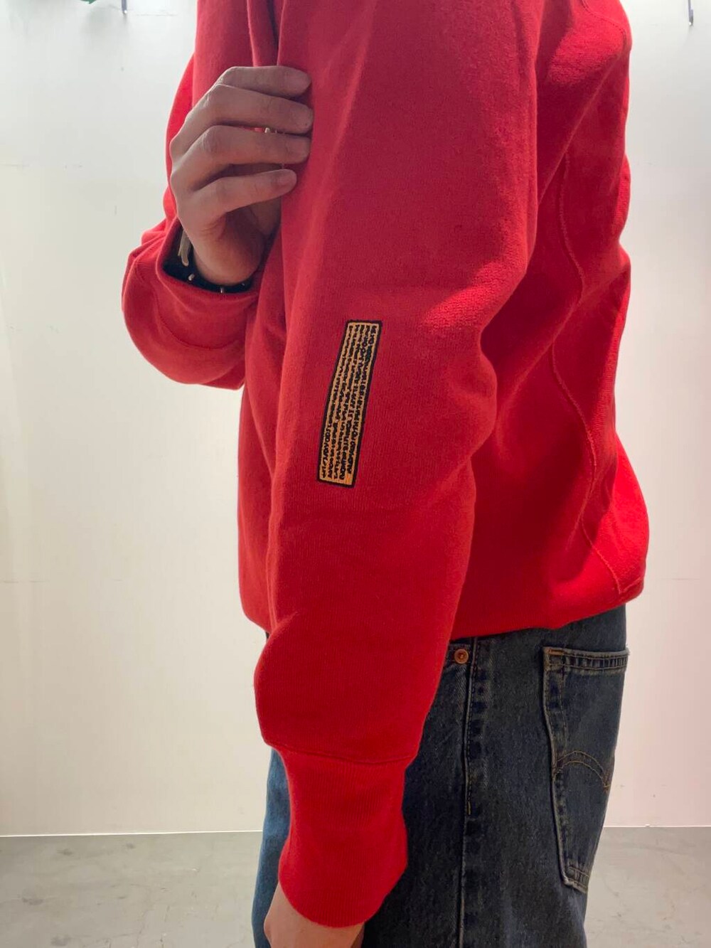 ブルー系のデニムパンツ、レッド系のスウェットを着用したメンズの冬コーディネートの4枚目の写真