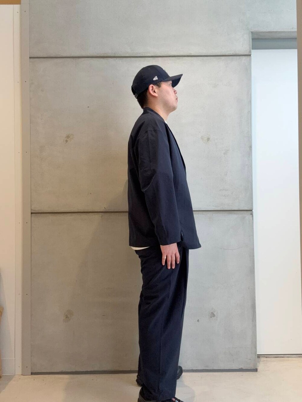 ホワイト系のTシャツ/カットソー、ブラック系のスニーカー、ブルー系のその他パンツを着用したメンズの春コーディネートの2枚目の写真