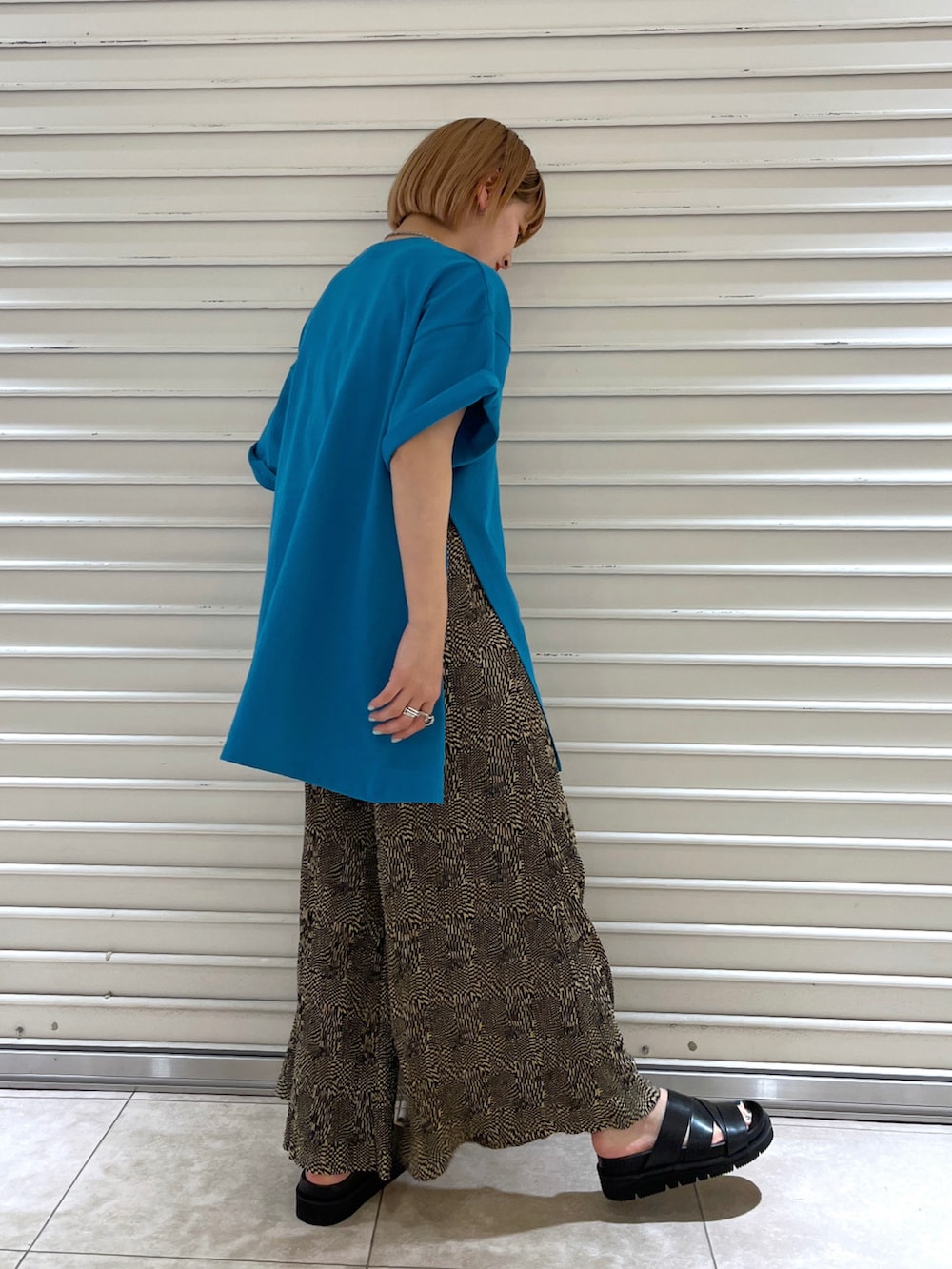 ブルー系のTシャツ/カットソー、ブラウン系のその他パンツ、ブラック系のサンダルを着用したレディースの春コーディネートの2枚目の写真