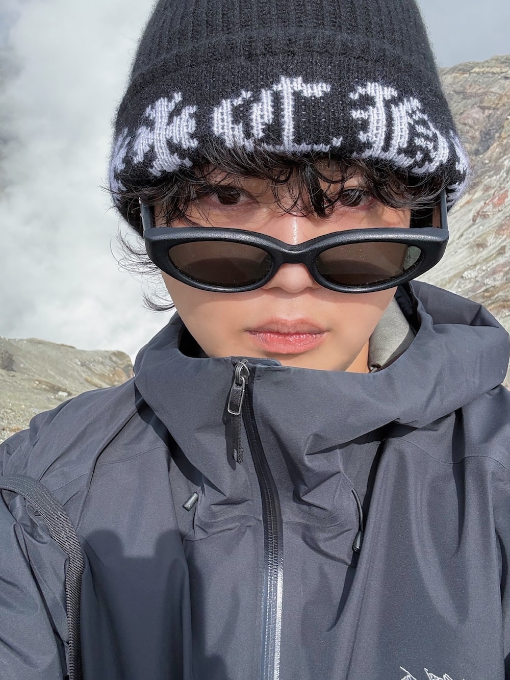 ブラック系のトートバッグ、ブラック系のマウンテンパーカー、ブラウン系のスニーカーを着用したメンズの冬コーディネートの4枚目の写真