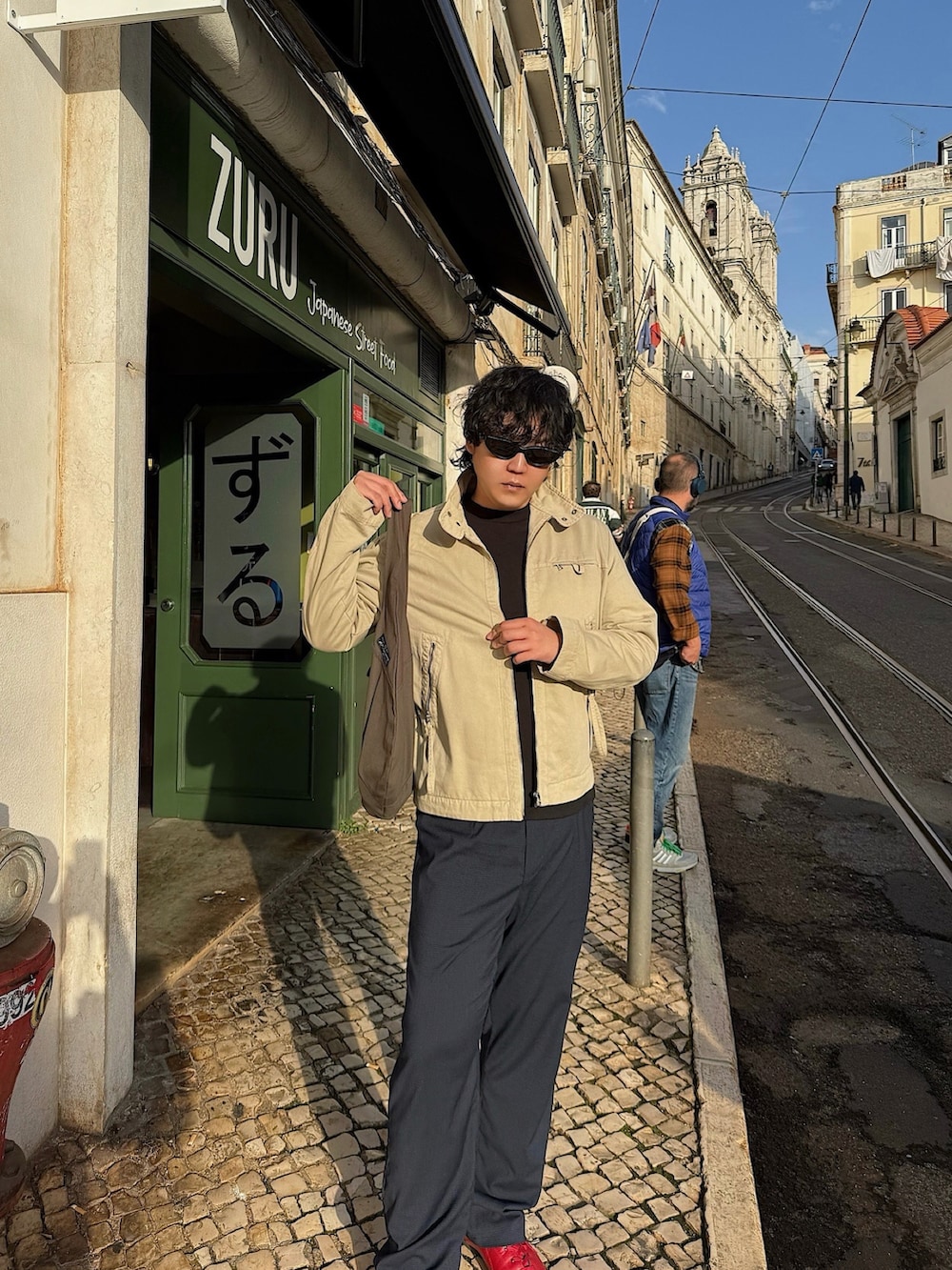 ベージュ系のジャケット/アウター、ブラック系のサングラスを着用したメンズの冬コーディネートの5枚目の写真