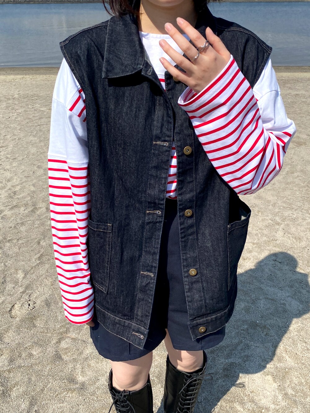 ブルー系のベスト、ブラウン系のショルダーバッグを着用したレディースの春コーディネートの2枚目の写真