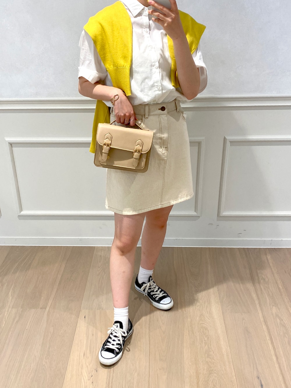 イエロー系のカーディガン/ボレロ、ホワイト系のシャツ/ブラウスを着用したレディースの春コーディネートの2枚目の写真