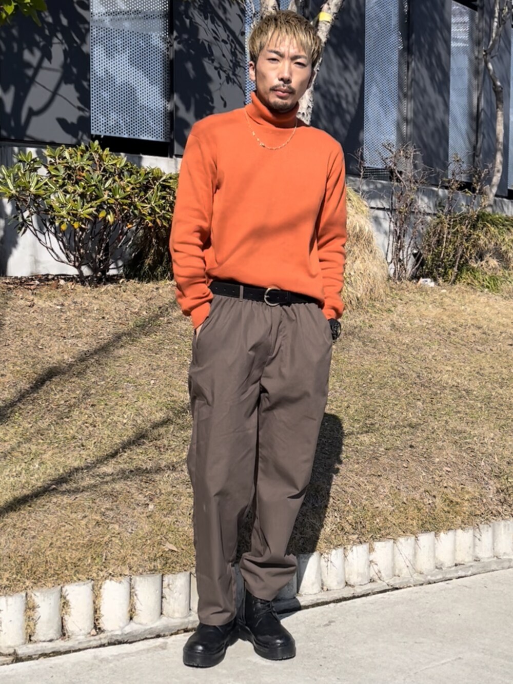 オレンジ系のニット/セーター、ブラウン系のその他パンツを着用したメンズの冬コーディネートの2枚目の写真