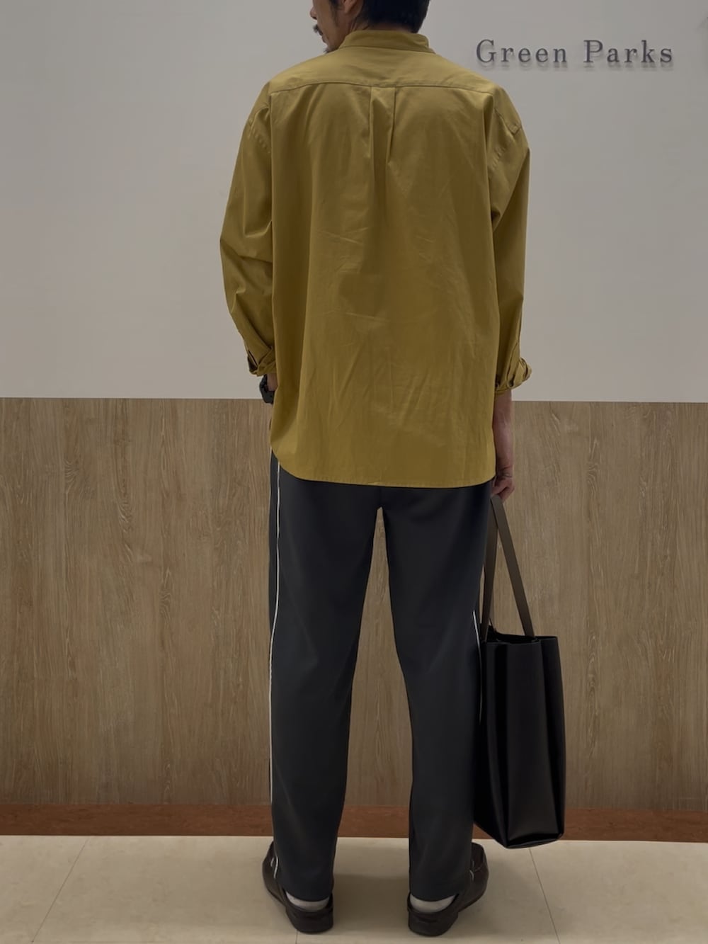 イエロー系のシャツ/ブラウス、グレー系のスウェットパンツ、ブラック系のバッグを着用したメンズの春コーディネートの2枚目の写真