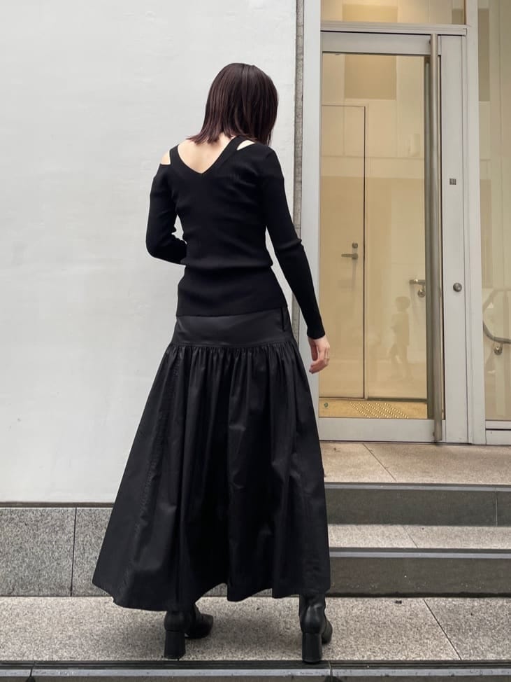ブラック系のスカート、ブラック系のブーツ、ブラック系のニット/セーターを着用したレディースの夏コーディネートの2枚目の写真