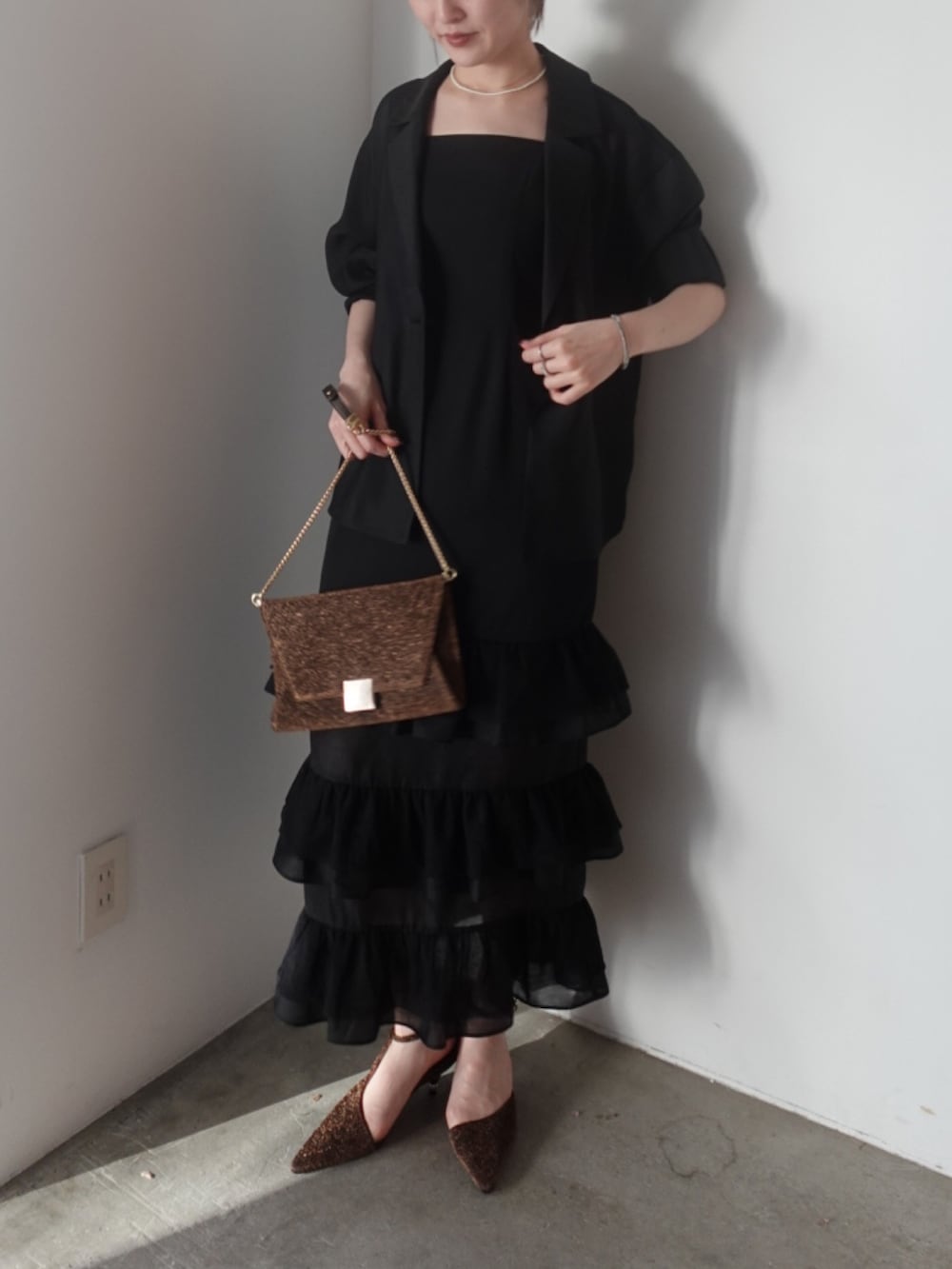 その他のパンプス、その他のクラッチバッグ、ブラック系のドレスを着用したレディースの夏コーディネートの9枚目の写真