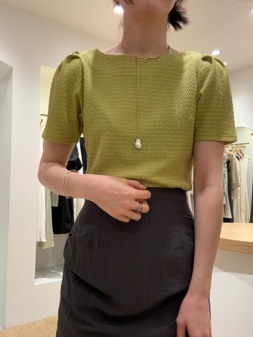 ブラック系のサンダル、グレー系のスカート、グリーン系のTシャツ/カットソーを着用したレディースの夏コーディネートの3枚目の写真