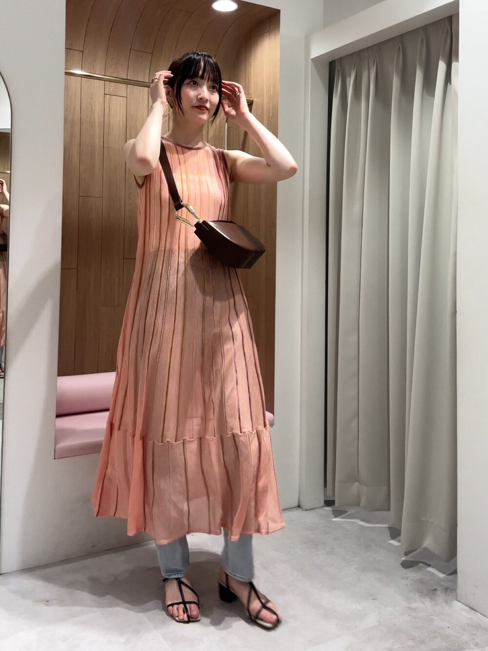 ブラック系のサンダル、ブルー系のデニムパンツ、ブラウン系のショルダーバッグを着用したレディースの夏コーディネートの4枚目の写真