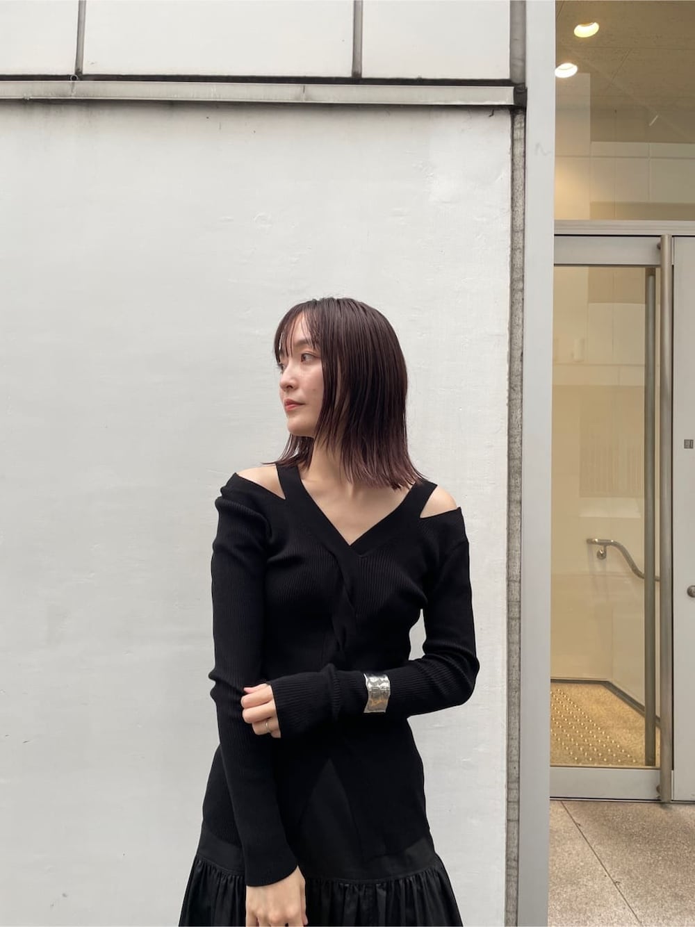 ブラック系のスカート、ブラック系のブーツ、ブラック系のニット/セーターを着用したレディースの夏コーディネートの5枚目の写真
