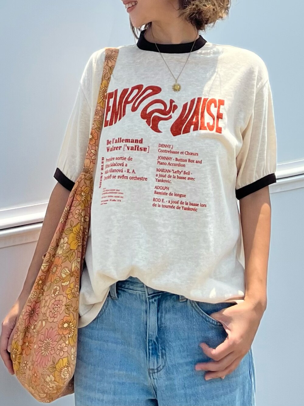 ベージュ系のTシャツ/カットソー、ブラウン系のショルダーバッグ、ブルー系のデニムパンツを着用したレディースの夏コーディネートの3枚目の写真