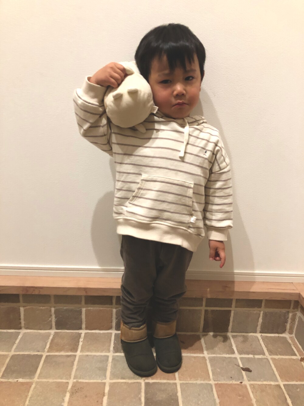 ホワイト系のパーカー、ブラウン系のパンツ、その他のブーツを着用したキッズの冬コーディネートの2枚目の写真