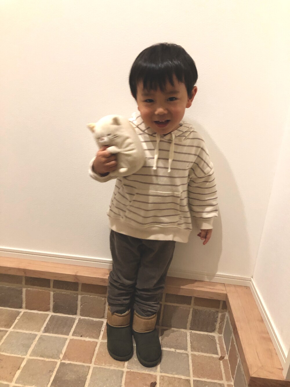 ホワイト系のパーカー、ブラウン系のパンツ、その他のブーツを着用したキッズの冬コーディネートの3枚目の写真