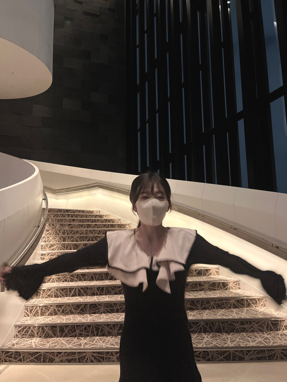 ブラック系のワンピース、ホワイト系のパンプスを着用したレディースの春コーディネートの3枚目の写真