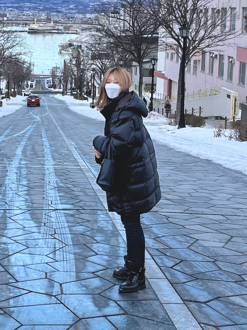 ブラック系のダウンジャケット/コート、ブルー系のデニムパンツ、ブラック系のブーツを着用したレディースの冬コーディネートの2枚目の写真