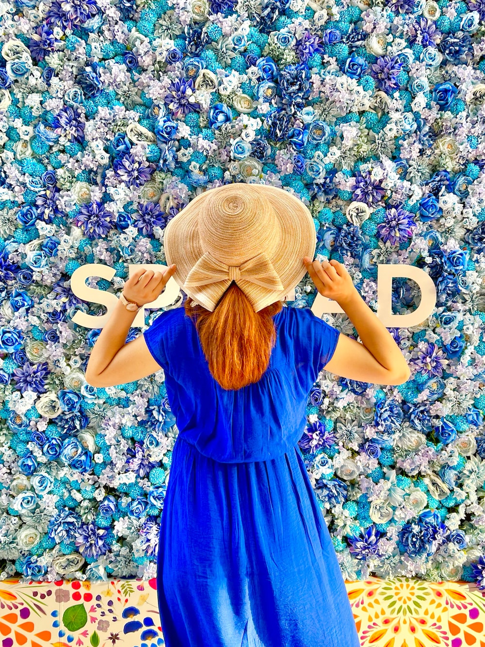 ブルー系のワンピース、ホワイト系のサンダル、ベージュ系のハットを着用したレディースの夏コーディネートの5枚目の写真