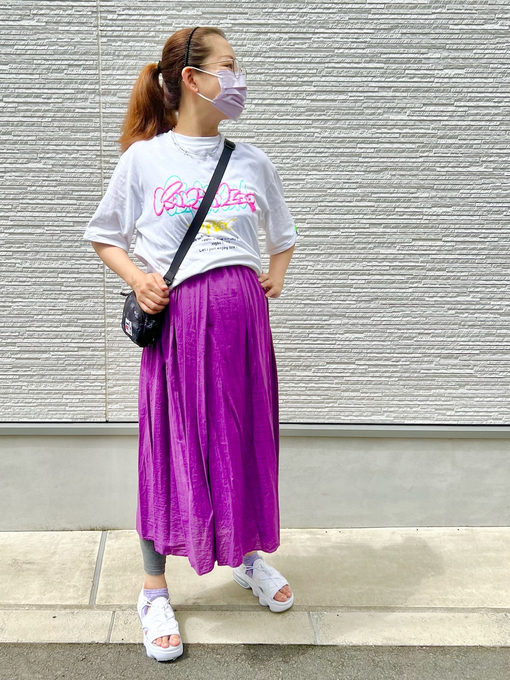 パープル系のワンピース、ホワイト系のTシャツ/カットソー、ブラック系のショルダーバッグを着用したレディースの夏コーディネートの4枚目の写真