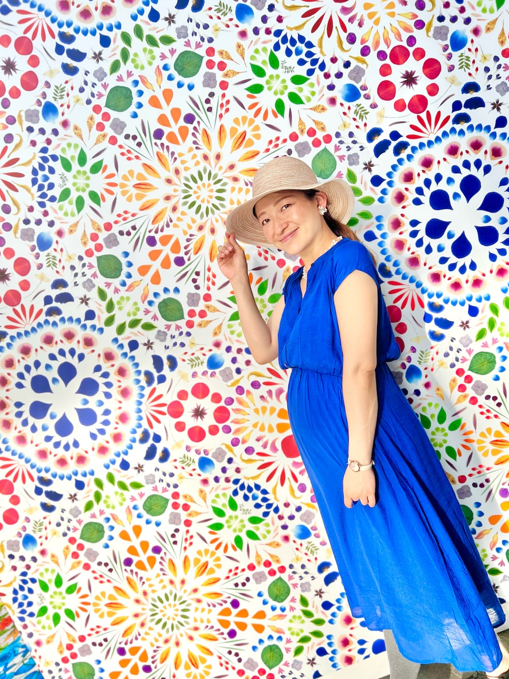 ブルー系のワンピース、ホワイト系のサンダル、ベージュ系のハットを着用したレディースの夏コーディネートの2枚目の写真