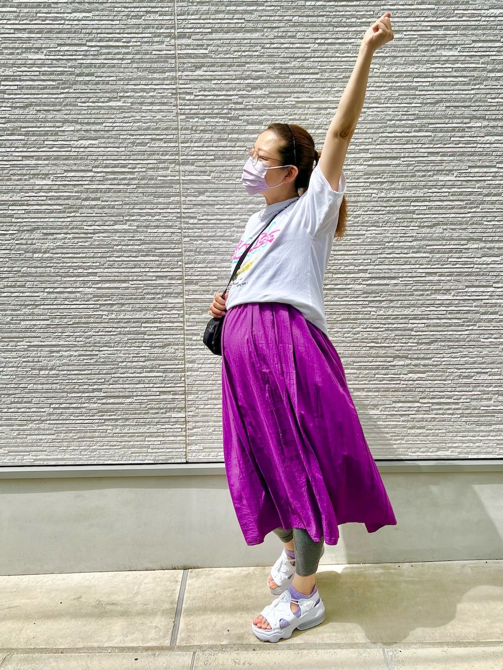 パープル系のワンピース、ホワイト系のTシャツ/カットソー、ブラック系のショルダーバッグを着用したレディースの夏コーディネートの5枚目の写真